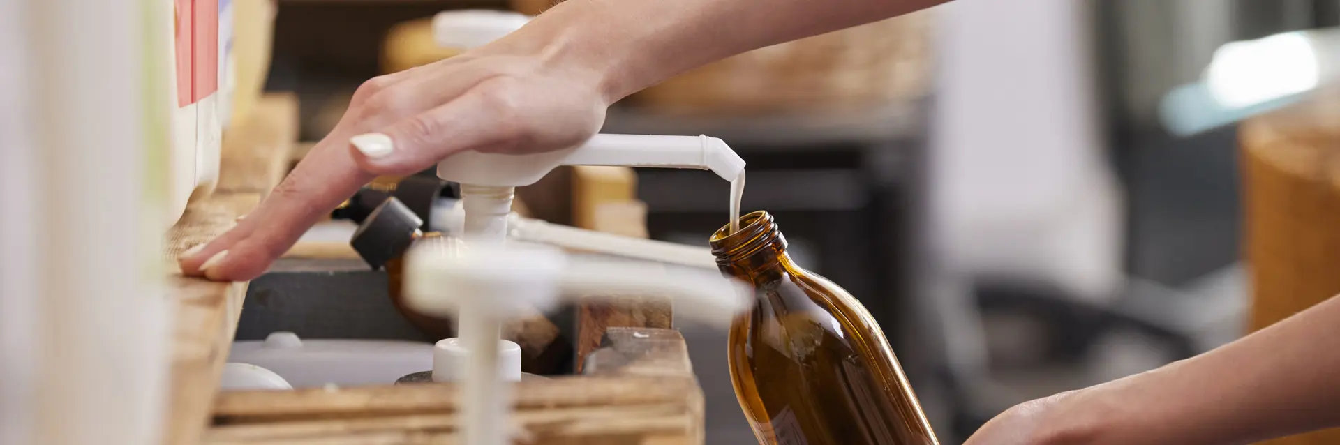 Someone refilling refillable bottle with pump of product