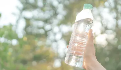 Someone holding up a plastic bottle