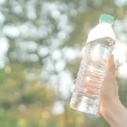 Someone holding up a plastic bottle