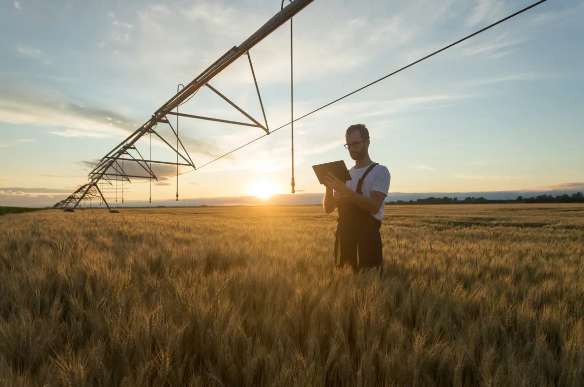 Man stood in a grass field with clipboard